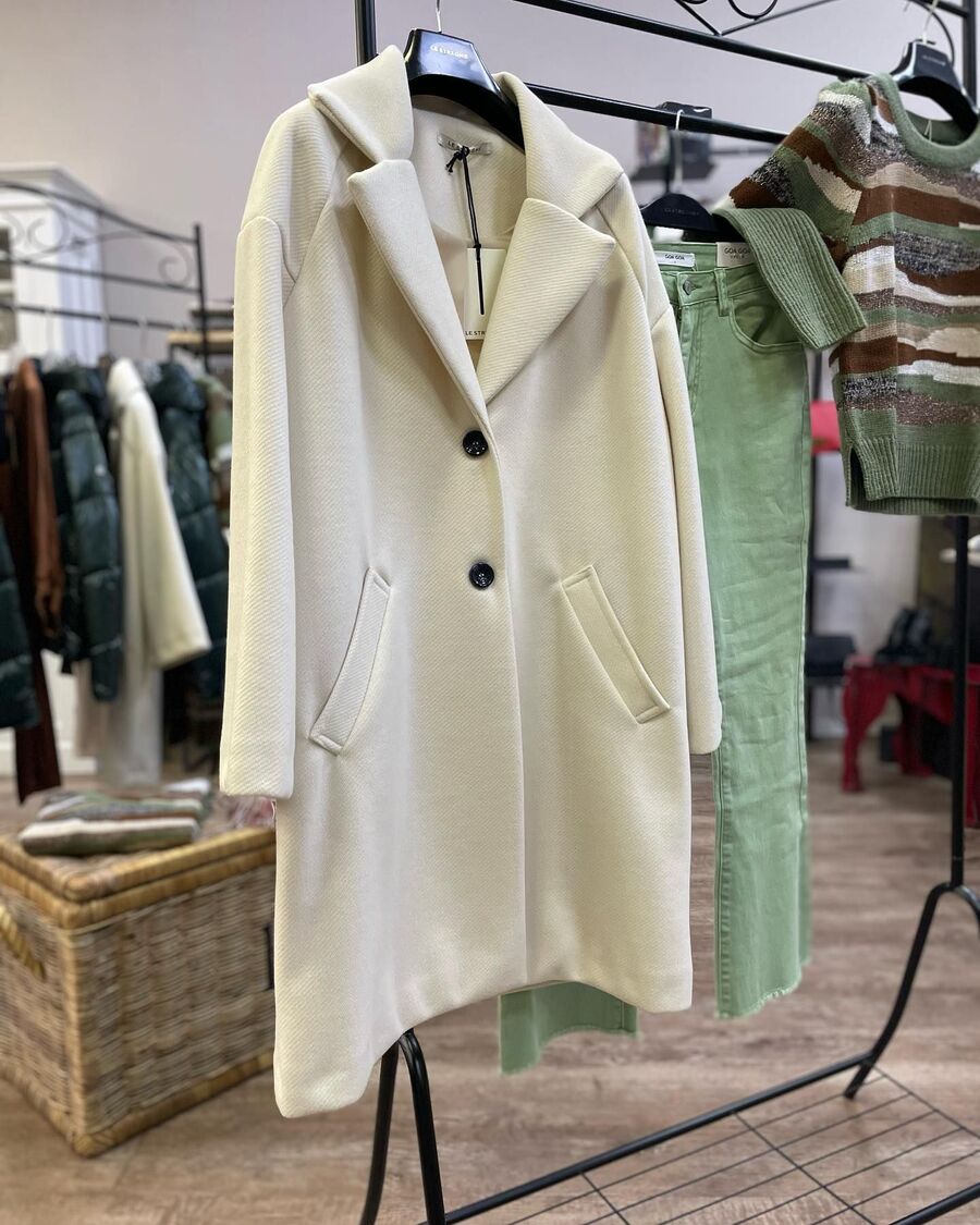 Cappotto bianco appeso a uno stand in negozio